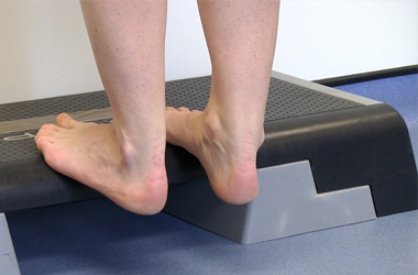 Eccentric calf stretch on a slant board for heel pain and Achilles rehabilitation