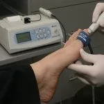 Handheld Doppler ultrasound being used to check circulation in a diabetic patient's foot