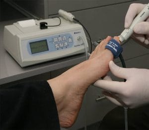Handheld Doppler ultrasound being used to check circulation in a diabetic patient's foot